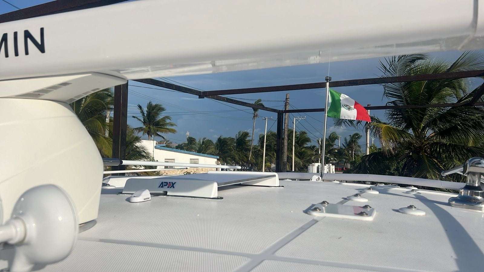 Starlink Standard Gen 3 Surface Mount on a boat with palm trees and a flag in the background.