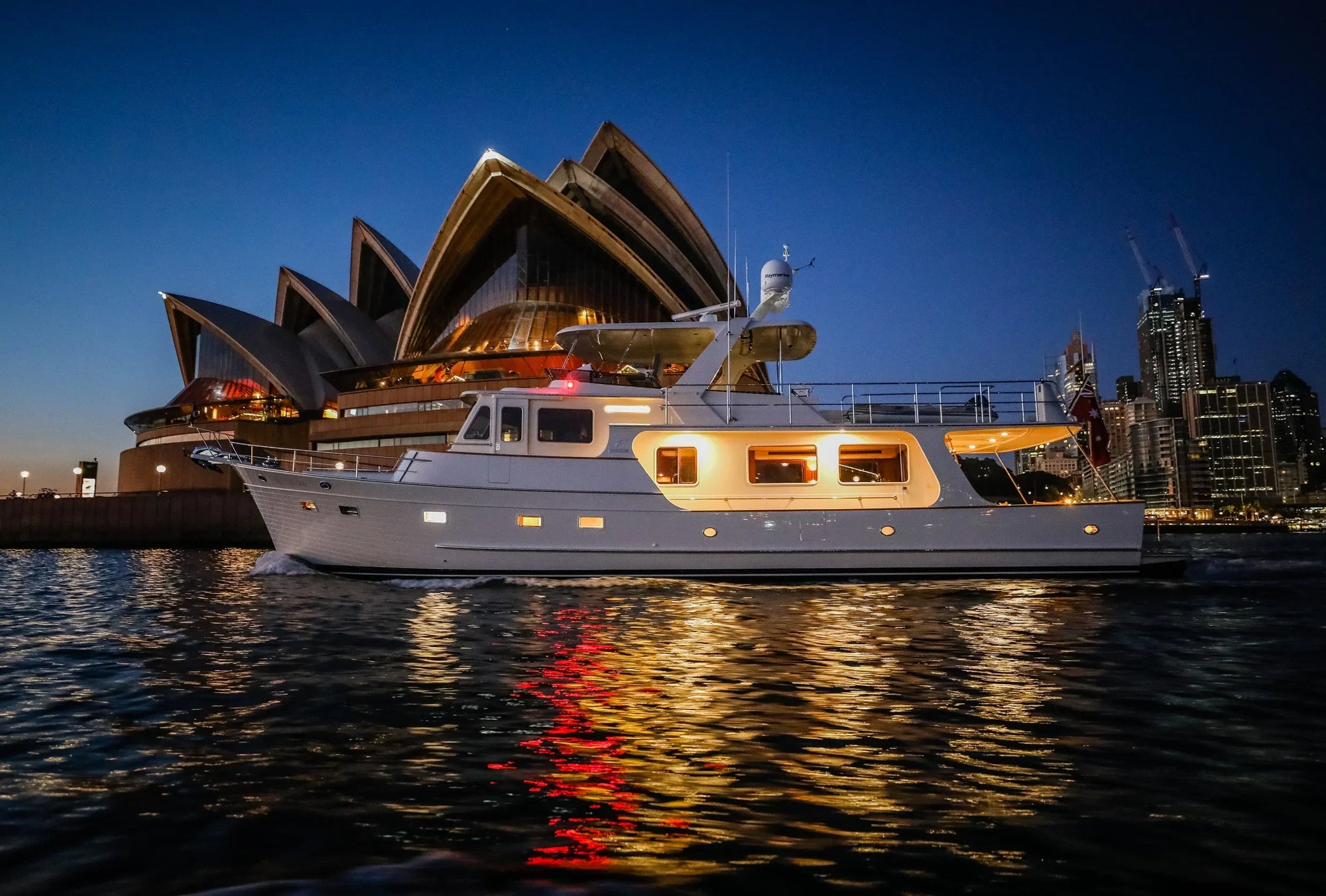 Fleming 65 yacht with customized Model #72 mast at night near iconic architecture.