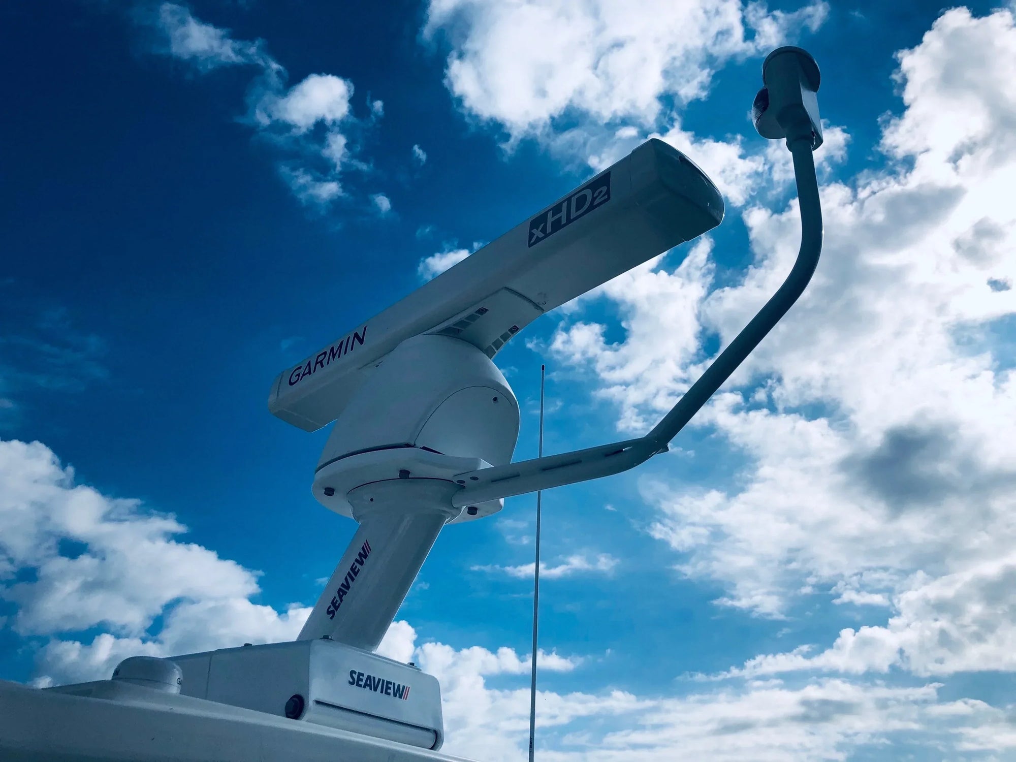 Seaview electrically actuated hinge mounted on a boat under cloudy sky.