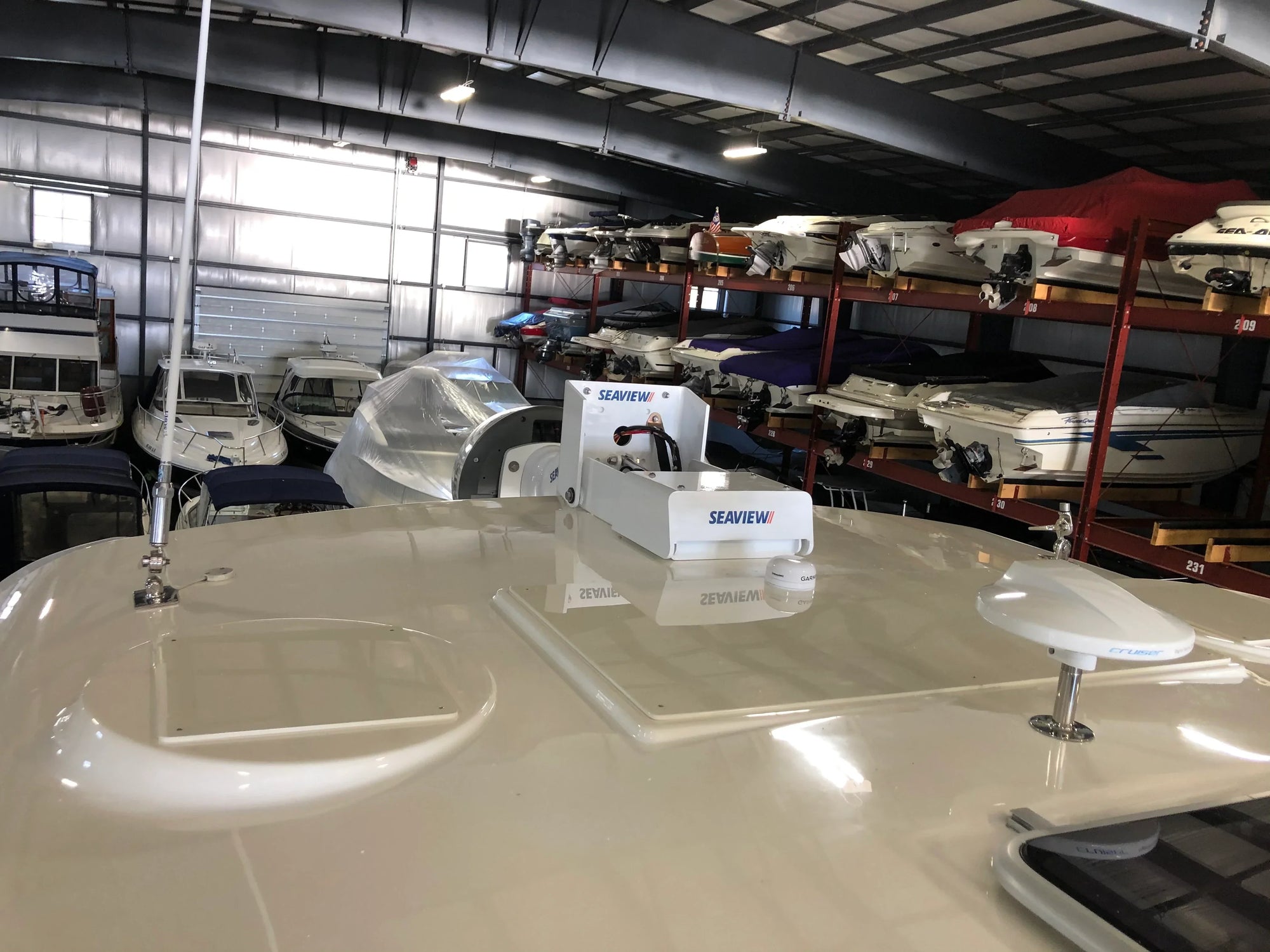 Seaview electrically actuated hinge on boat roof with parked boats in the background.